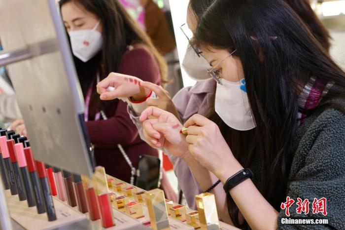 圖為女生正在體驗(yàn)口紅產(chǎn)品。 殷立勤 攝