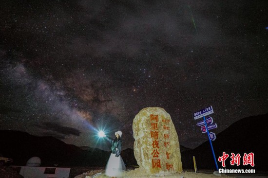 圖為6月20日晚，游客“打卡”西藏阿里暗夜公園，天上是銀河與流星（右上角）。曹枝清 攝