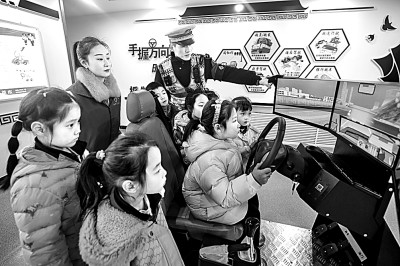 山東省榮成市公安局道路交通安全宣傳教育基地,交警帶領(lǐng)小學(xué)生現(xiàn)場體驗(yàn)?zāi)M駕駛。新華社發(fā)