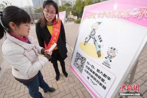 資料圖：今年3月8日，安徽合肥新華社區(qū)志愿者夏一瓊(右)向市民普及反家暴相關(guān)法律知識(shí)。鐘欣 攝